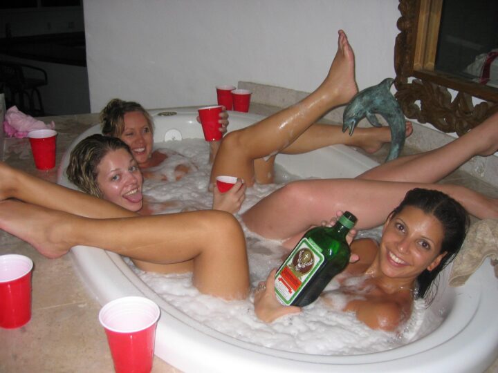 Пьяные девчонки сидят в ванной с голыми ногами и пьют алкоголь