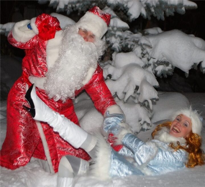 Дед Мороз тащит пьяную Снегурочку из сугроба.